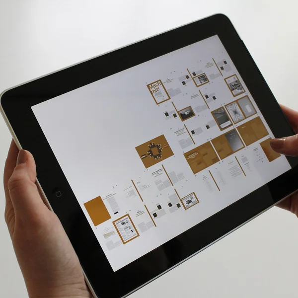 Woman holding an iPad displaying a publishing app